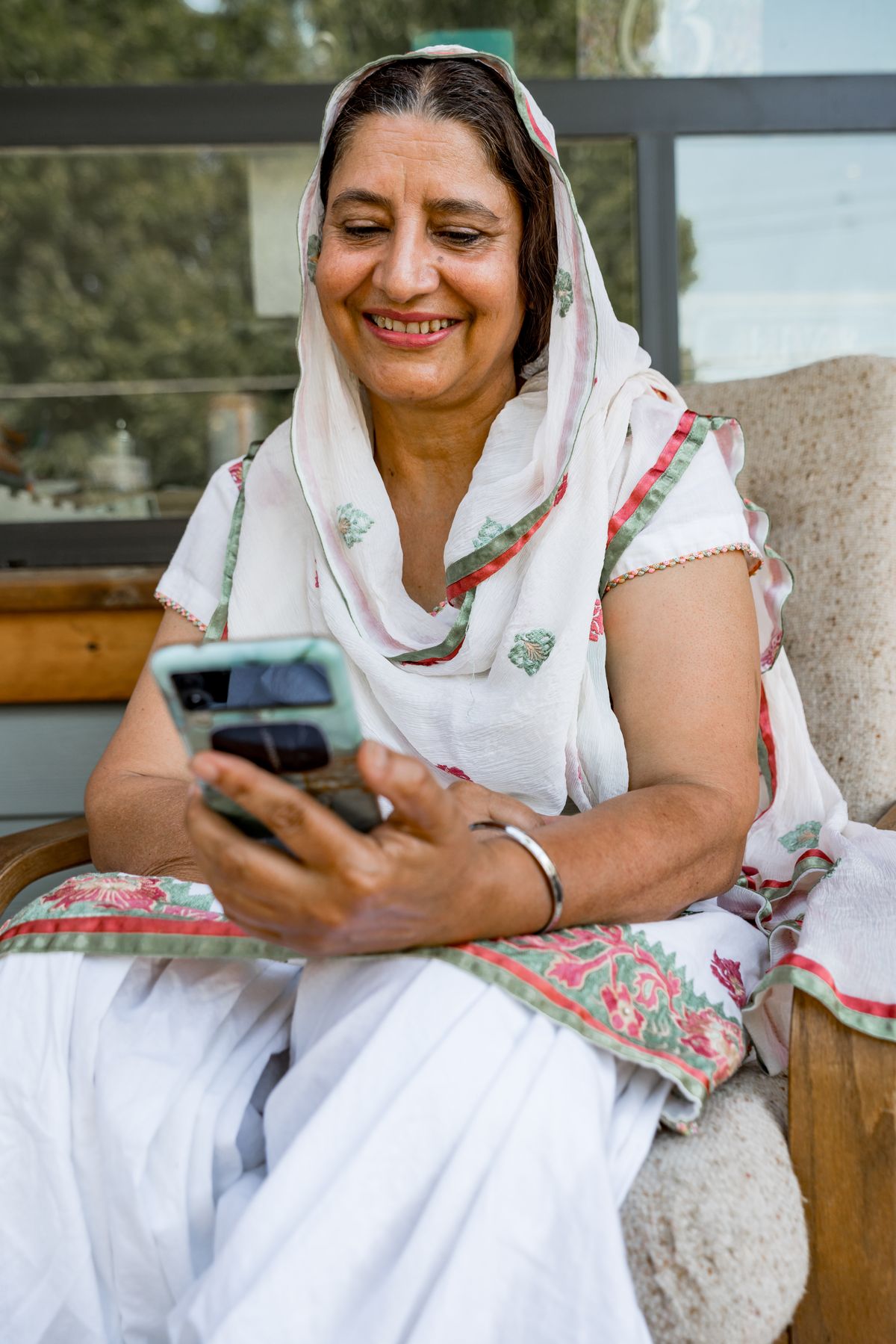An older woman reading a message on her phone